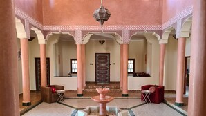 Un interior espacioso con una fuente central, techos altos y arcos tradicionales.