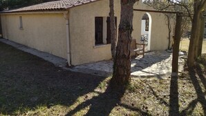 A small, single-story building with a tiled roof and a beige exterior. - Charming studio 25 min from vallon pont d'arc (Le Garn)