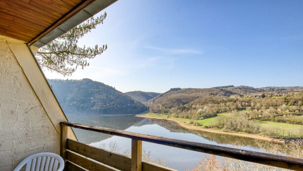 A balcony with a table and chairs overlooking a calm river and hilly landscape. - Vacancéole - Le Domaine de Confolant (Miremont)