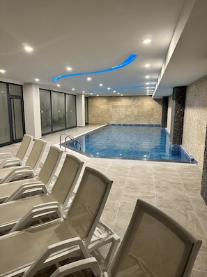 Una piscina cubierta, una piscina al aire libre de temporada, sombrillas