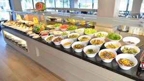 Ein reichhaltiges Buffet mit verschiedenen Speisen und einer Wassermelone.