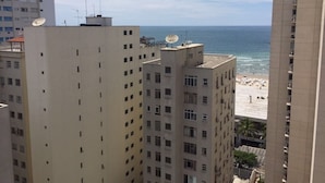 A high-rise hotel overlooking a beach with multiple balconies and a clear view of the sea. - Apartment with beautiful sea view - Praia de Pitangueiras (Guarujá)