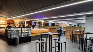 A modern cafe with a counter, display cases, and seating areas.
