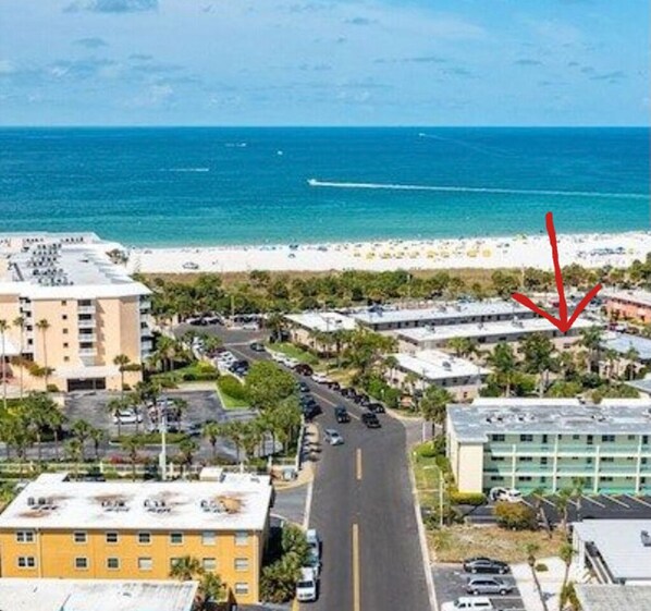 An aerial view of a coastal area with buildings, roads, and a beach.