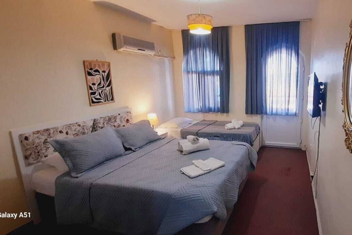 A hotel room with two beds, a large mirror, and a ceiling fan.
