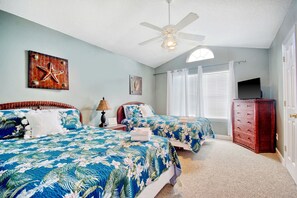 A bedroom with two beds, a ceiling fan, a TV, and a dresser. - Just Beachy | Beautiful Beach Home with Heated Pool (Surfside Beach)