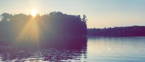 A calm lake with a sunlit island in the center.