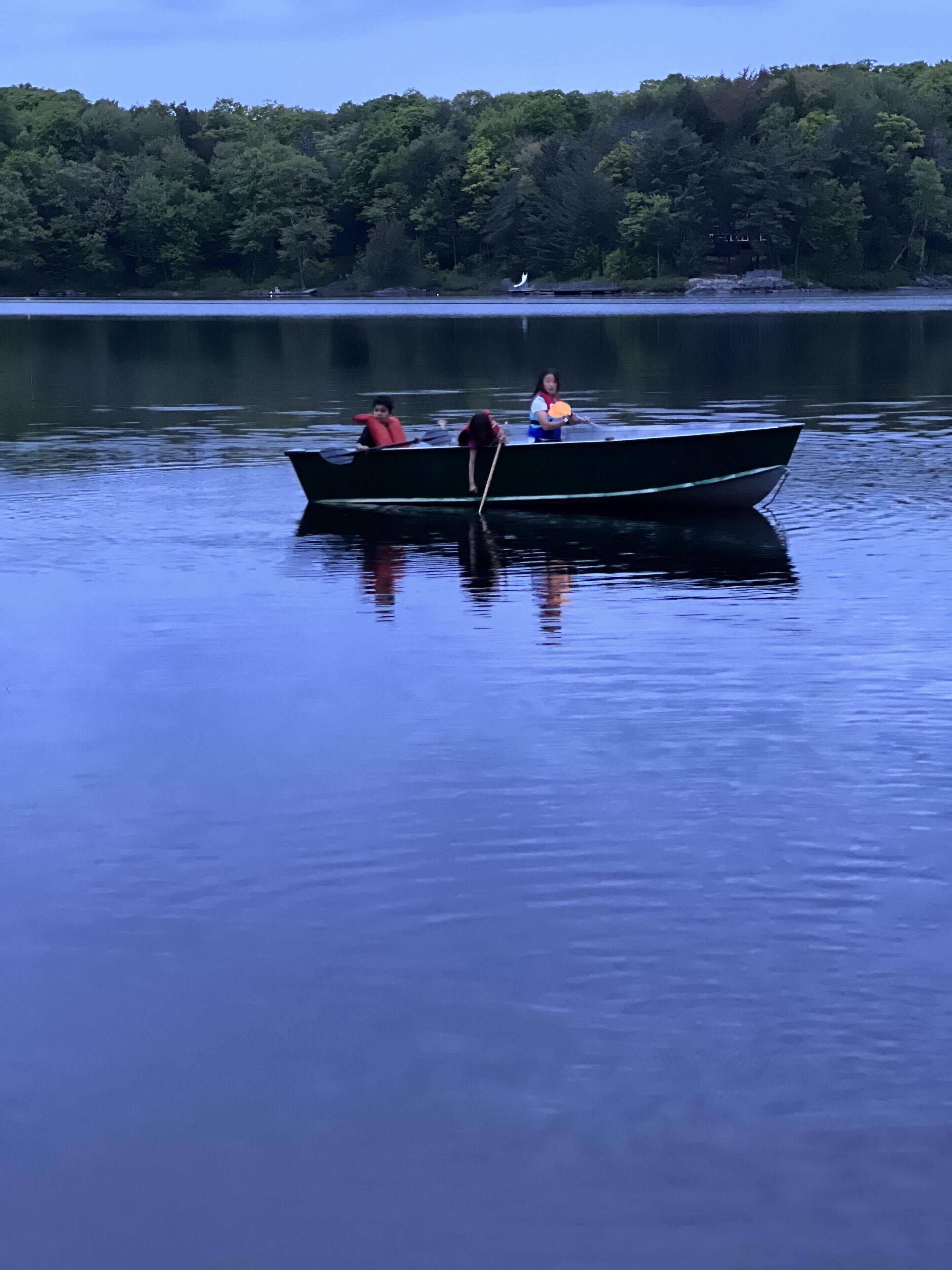 A calm lake with a small boat anchored near the shore.