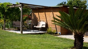 Un patio con un pérgola, una mesa y dos sillas.