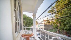 A balcony with white railings, a small round table, and white chairs. - Fully Equipped 1BR Studio ->DT->2Mins to the Beach (sosua)