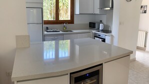 A modern kitchen with a central island, stainless steel appliances, and a wine cooler. - FAMILY VILLA WITH POOL NEAR MORAIRA (Teulada)