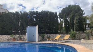 A swimming pool with a tiled edge, surrounded by a stone wall and a row of sun loungers. - FAMILY VILLA WITH POOL NEAR MORAIRA (Teulada)