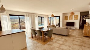 Amplia sala de estar con mesa de comedor, sofá y televisor.
