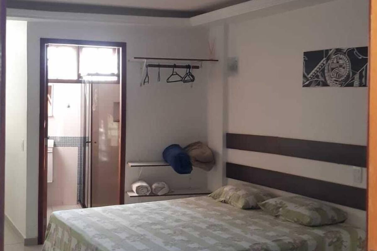 Une chambre à coucher comprenant un lit, une table de chevet, une armoire et une porte donnant sur une autre pièce.