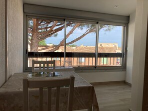 A room with a large window, a table, and a chair.