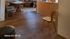 A spacious room with wooden beams, a dining area, and a kitchen. - Wellnesshof Müller Vorderburg (Rettenberg)