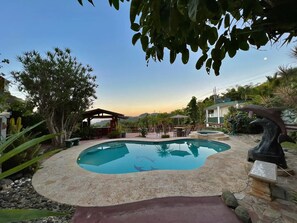 A swimming pool with a stone deck, surrounded by greenery and a gazebo. - Pancho's Paradise (Canóvanas)