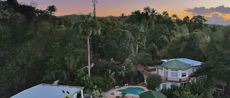 Un resort con piscina, varias construcciones y abundante vegetación.