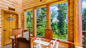 A wooden cabin with a dining area, large windows, and a door labeled "Home Theater".