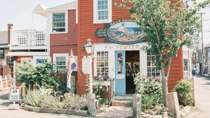 A red building with a sign reading "Bear Skinning" and "The Pewter" shop. - Bearskin Neck Rental in the Heart of Rockport! Walk to Beaches + Restaurants! (Rockport)