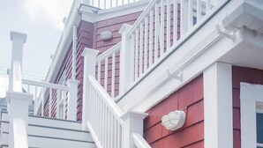 A staircase with white railings leading to a red building with white trim. - Bearskin Neck Rental in the Heart of Rockport! Walk to Beaches + Restaurants! (Rockport)