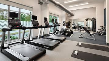 A gym with treadmills, exercise bikes, and weight machines.