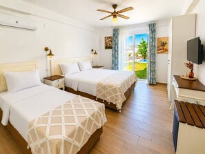 A hotel room with two beds, a ceiling fan, a television, and a view of the outdoors. - Alacati Fora Bella (Cesme)