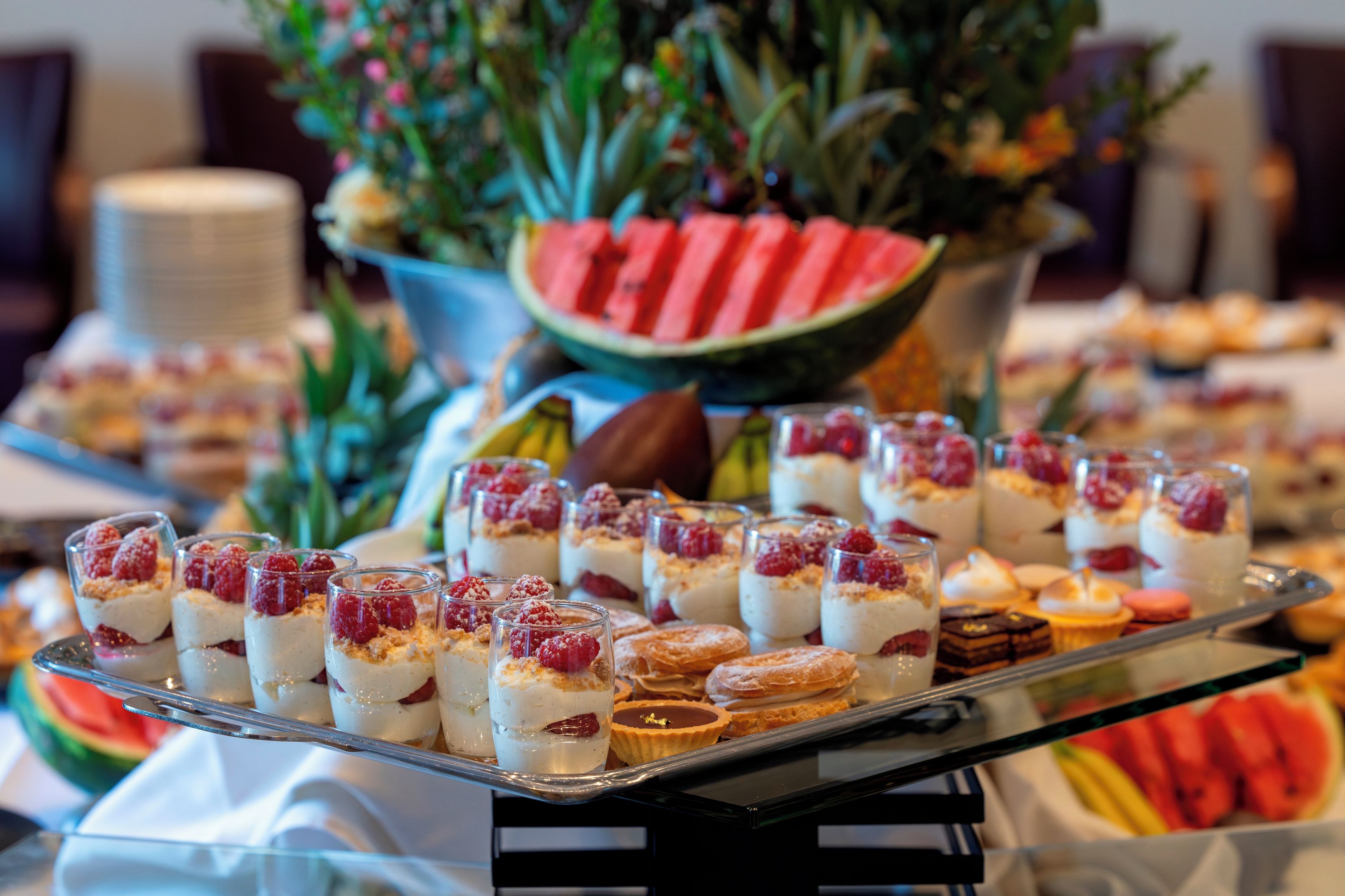 A buffet table with various desserts and fruits.