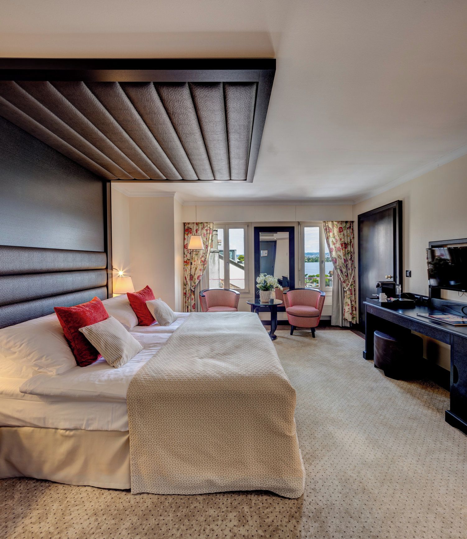 Ein Hotelzimmer mit Bett, Schreibtisch und Blick ins Freie.