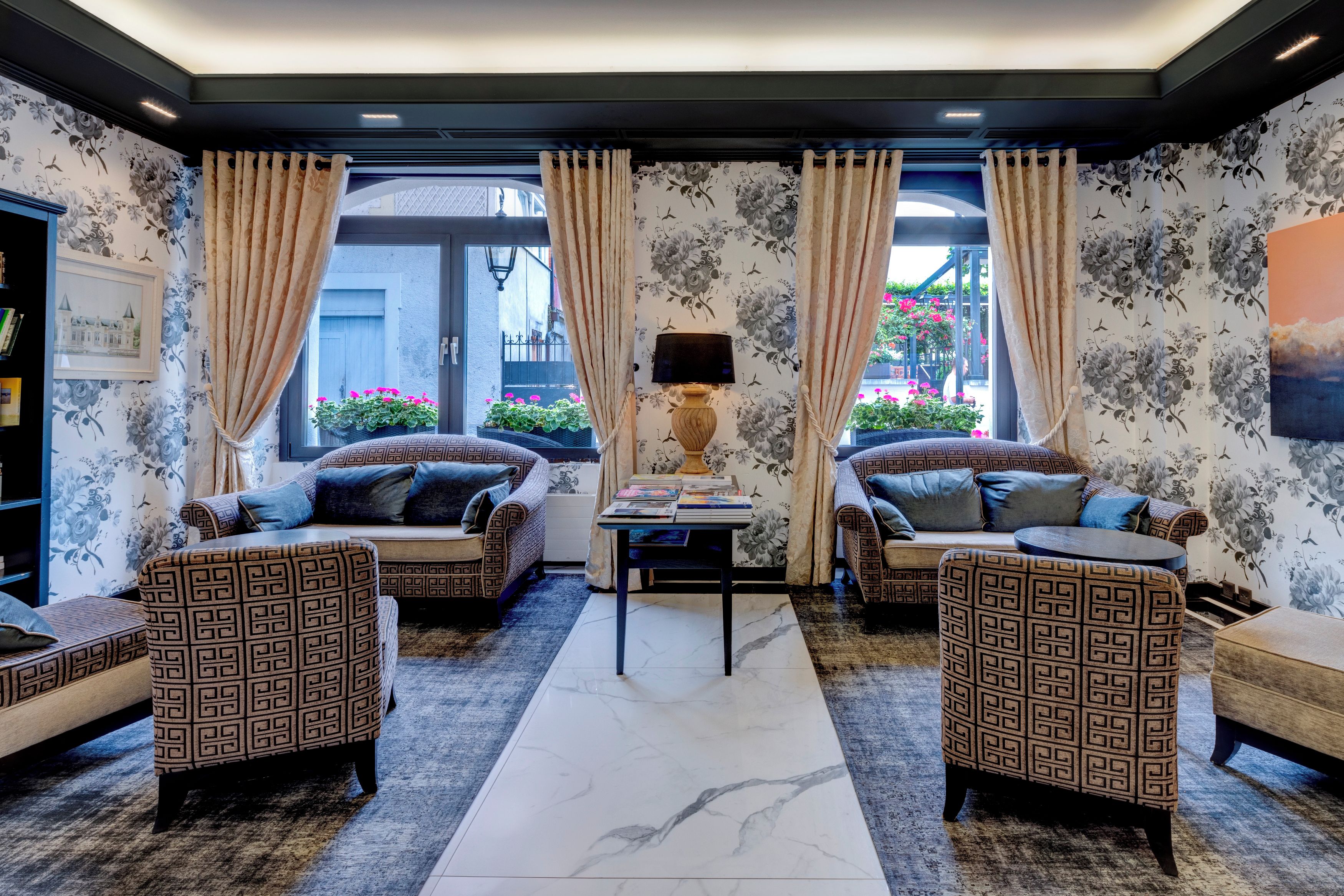 Une chambre d’hôtel avec deux canapés, une table basse et une lampe.