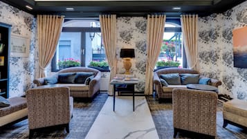 Habitación de hotel con dos sofás, una mesa de centro y una lámpara.