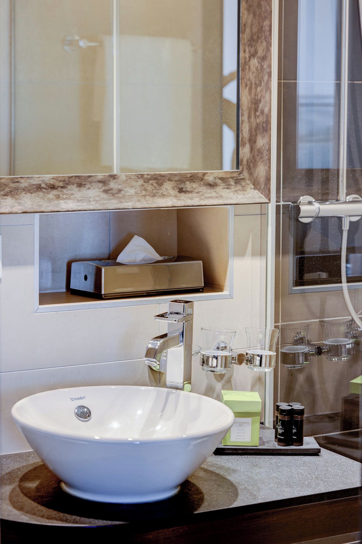 A bathroom with a white sink, a mirror, a towel rack, and a shower area.