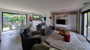 Un salon moderne avec un canapé, une table basse et un téléviseur.