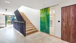 A modern interior with a staircase, a wooden door, and a colorful wall. - Apartamenty Sun & Snow Na Wydmach (Dziwnów)