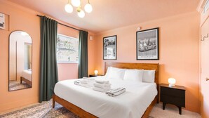 A bedroom with a bed, a nightstand, a mirror, and two framed pictures on the wall. - 101 · ☀Pool✔ Beach✔ Self Checkin✔ Free Parking✔ (Clearwater)