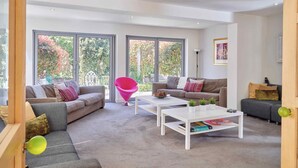 A modern living room with two sofas, a coffee table, and a bright window view. - The Chase (Cheltenham)