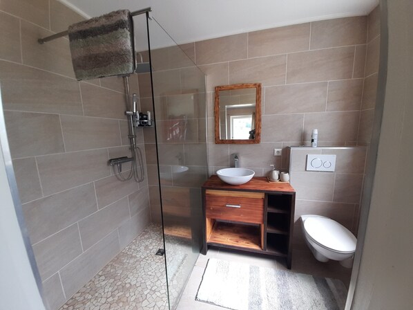 A modern bathroom with a glass shower enclosure, a wooden vanity with a white sink, and a toilet. - An incredibly beautiful vacation home in the Southern Black Forest (Sankt Blasien)