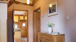 A wooden hallway with a welcome sign, a vase with flowers, and a framed picture on the wall. - 1 bedroom accommodation in Kingsland (Kingsland)