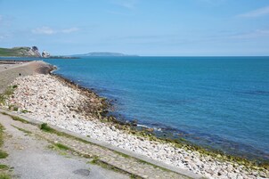 Uma estrada costeira com um litoral rochoso e vista clara para o mar.