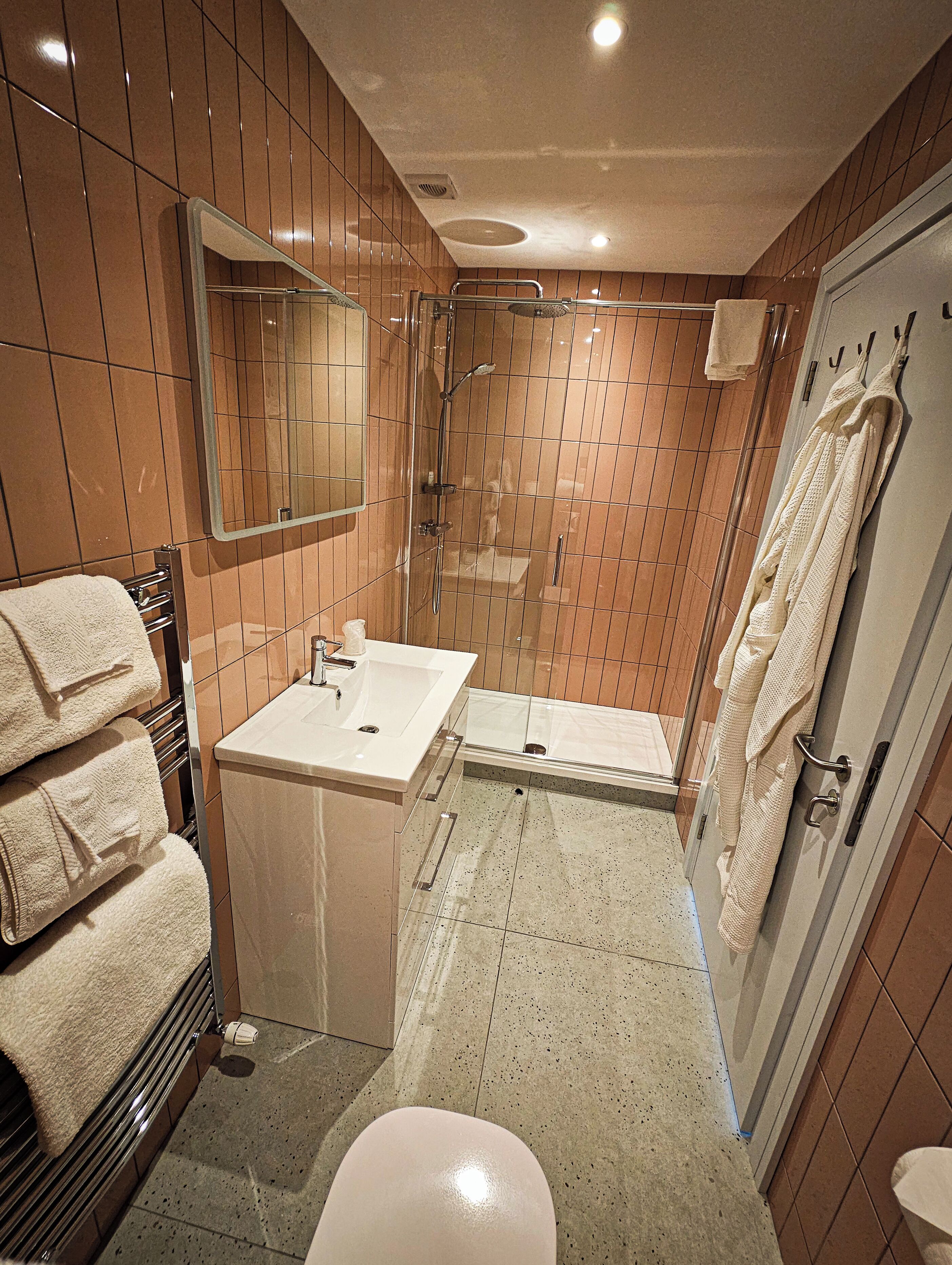 A bathroom with a shower, sink, and toilet.