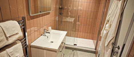 A bathroom with a shower, sink, and toilet.