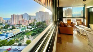 Un appartement moderne avec vue sur la ville, de grandes fenêtres et un balcon.