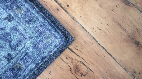 A wooden floor with a blue patterned rug. - James Pharmacy Bed & Breakfast (Old Saybrook)