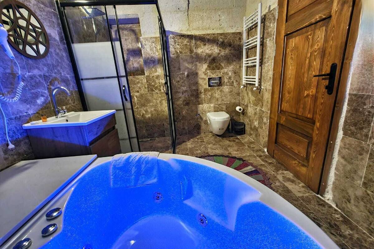 A bathroom with a bathtub, a sink, a toilet, and a wooden door.