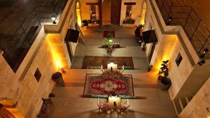 A courtyard with a central seating area, a staircase, and a view of the upper floors. - Lavinia Cappadocia (Ürgüp)
