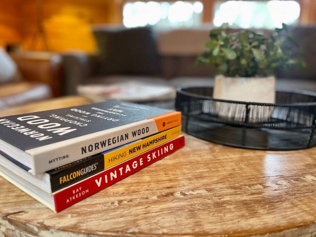 Una pila de libros sobre una mesa de madera.
