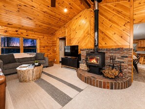 A log cabin interior with a fireplace, a sofa, a television, and a dining area. - Family&Pet Friendly*SLOPE SIDE*Fireplace*Stylish (Bartlett)
