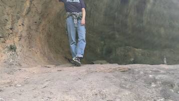 Una persona de pie en una cueva con un interior rocoso y accidentado.
