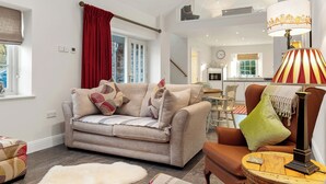 Un salon moderne avec un canapé, une table basse et une lampe.