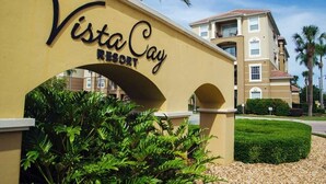 The entrance to Vista Cay Resort with a clear archway and a building in the background. - Spacious and Modern Townhome! Close to Attractions and Conventions Center! 3vc5014-10 (Orlando)